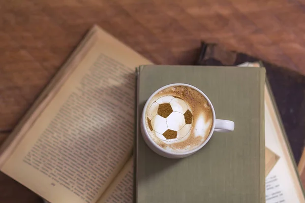 background of cappuccino in cup with a pattern of soccer ball on a milk foam