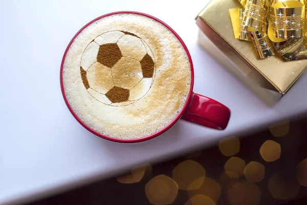 background of cappuccino in cup with a pattern of soccer ball on a milk foam