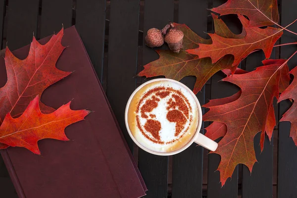 a cup of cappuccino coffee with a pattern of the planet earth made of cinnamon on milk foam