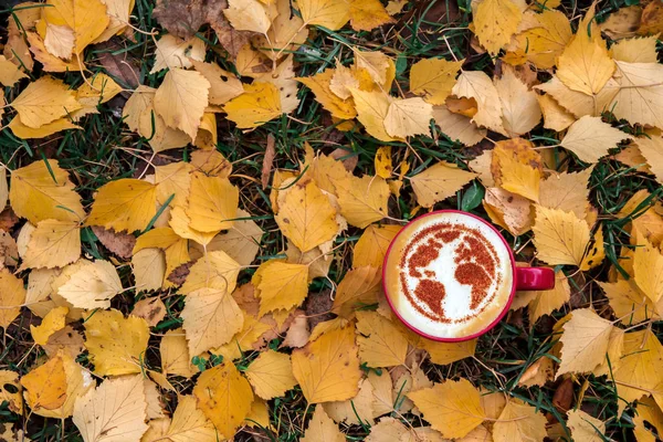 a cup of cappuccino coffee with a pattern of the planet earth made of cinnamon on milk foam