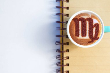Bir fincan cappuccino kahve ve burç sembolü.
