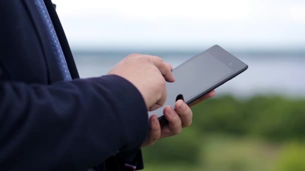 Άνθρωπος Που Εργάζεται Ένα Tablet Ένα Θολή Φόντο Του Ποταμού — Αρχείο Βίντεο