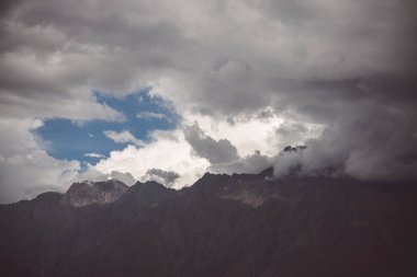 Bir görünümü dağların üzerinden güneş ışığı nüfuz bulutlarda kefen ve mavi gökyüzü görünür