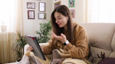 Güzel bir kız kanepede otururken arkadaşıyla internette sohbet ediyor.