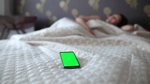 Chica Apaga Alarma Teléfono Con Una Pantalla Verde — Vídeo de stock