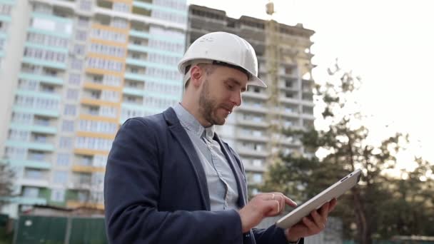Bauingenieur Mit Weißem Helm Ändert Baupläne Tablet — Stockvideo