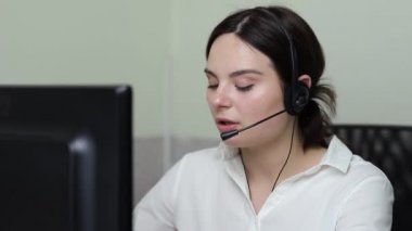 Çağrı merkezi çalışanı bir kulaklık kullanarak telefonla konuşuyor.