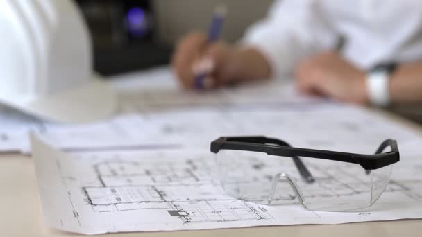 Architect making marks on construction drawings while sitting in the office