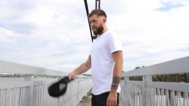 Adam kameraya bakar ve bir şapka takar.