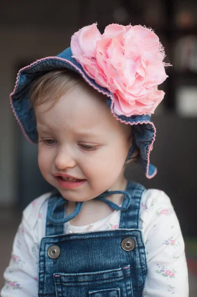 Crying offended baby girl in summer hat. Panama with a big pink flower — Stock Photo, Image