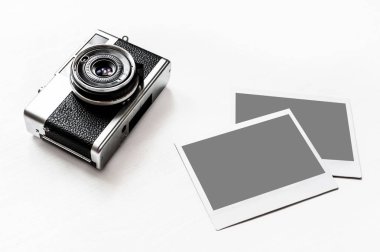 Resimlerinizi Flatlay vintage retro kamera boş anlık kağıt fotoğraf ahşap beyaz zemin üzerine yerleştirilir. Üstten görünüm