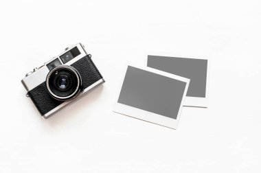 Resimlerinizi Flatlay vintage retro kamera boş anlık kağıt fotoğraf ahşap beyaz zemin üzerine yerleştirilir. Üstten görünüm