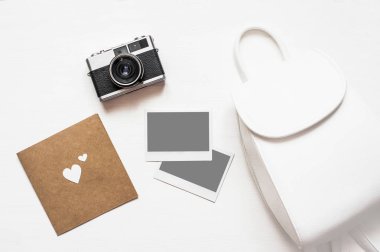 Resimlerinizi Flatlay vintage retro kamera boş anlık kağıt fotoğraf ahşap beyaz zemin üzerine yerleştirilir. Üstten görünüm