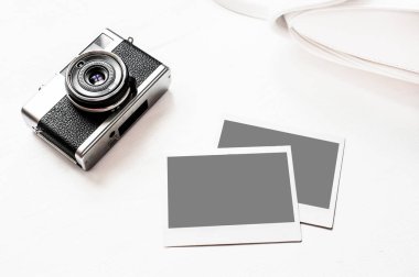 Resimlerinizi Flatlay vintage retro kamera boş anlık kağıt fotoğraf ahşap beyaz zemin üzerine yerleştirilir. Üstten görünüm