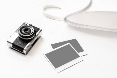 Resimlerinizi Flatlay vintage retro kamera boş anlık kağıt fotoğraf ahşap beyaz zemin üzerine yerleştirilir. Üstten görünüm