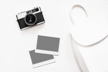 Resimlerinizi Flatlay vintage retro kamera boş anlık kağıt fotoğraf ahşap beyaz zemin üzerine yerleştirilir. Üstten görünüm