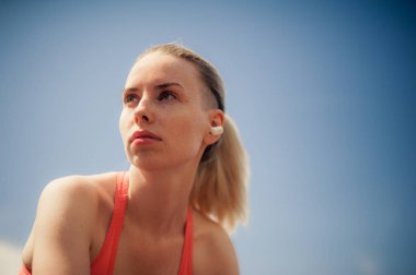 Kablosuz kulaklık müzik dinleme, sokakta Egzersiz egzersizleri yapıyor fitness kadın. Spor stil Bluetooth kulaklık