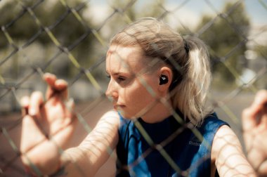 Kablosuz kulaklık müzik dinleme, sokakta Egzersiz egzersizleri yapıyor fitness kadın. Spor stil Bluetooth kulaklık