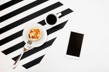 Şık minimalist çalışma alanı ile smartphone kadar kahve, ekmek şeritli siyah ve beyaz arka plan üzerinde sahte. Düz yatıyordu stil üstten görünüm. 