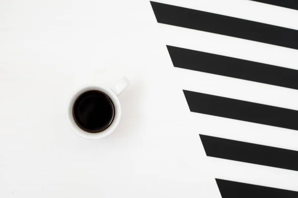 Şık minimalist fincan kahve ile çizgili siyah ve beyaz arka plan üzerinde izole. Düz yatıyordu stil üstten görünüm. — Stok fotoğraf
