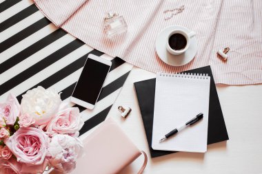 Ev ofis çalışma alanı. Defter ile boşaltmak. Düz lay, dergiler, sosyal medya. Üstten görünüm güzellik blog kavramı. Kadın moda aksesuarları, telefon ve kahve beyaz yatak zemin üzerine. 