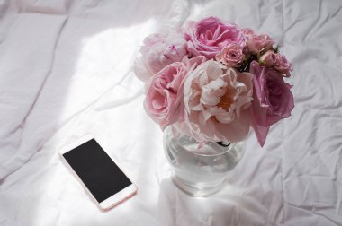 Güzellik düz telefon ve çiçek ile yatıyordu.