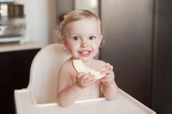A kislány enni dinnye. Vicces nevető gyermek a konyhában. Vidám gyerek a etetőszék — Stock Fotó