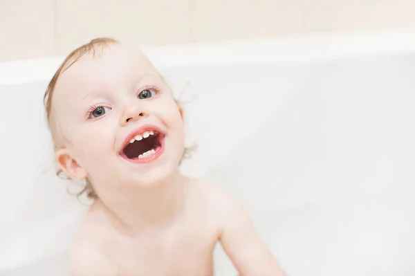 Feliz niña linda en el baño. Chico sonriente jugando con espuma. Niño riéndose lavando el cabello con champú . —  Fotos de Stock