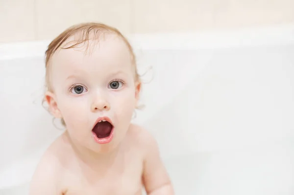 Joyeux bébé fille mignonne dans la salle de bain. Enfant souriant jouant avec la mousse. Enfant riant laver les cheveux avec shampooing . — Photo