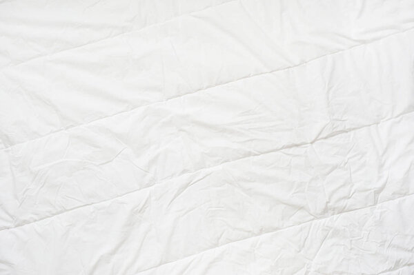 Смятое одеяло белой текстуры. Закрыть
. 