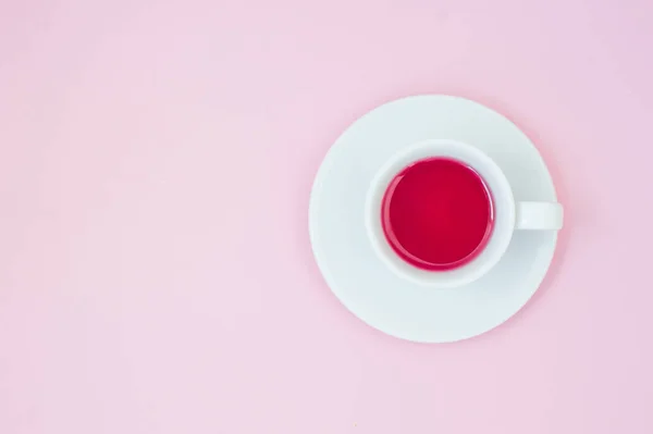 Fincan çay pastel pembe bir arka plan üzerinde. Kadınsı çalışma alanı. Düz yatıyordu, minimal kavramı, üstten görünüm. — Stok fotoğraf