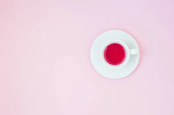 Tasse Tee auf pastellrosa Hintergrund. Weiblicher Arbeitsplatz. flache Verlegung, minimales Konzept, Draufsicht. — Stockfoto