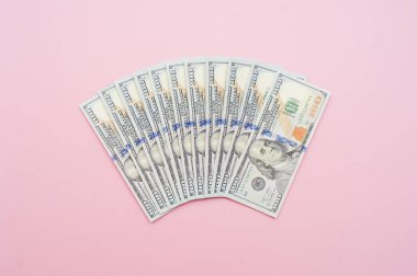 Yeni yüz dolarlık banknot yelpaze şeklinde. Pastel pembe bir arka plan üzerinde banknot, yakın çekim. Para kavramı. 