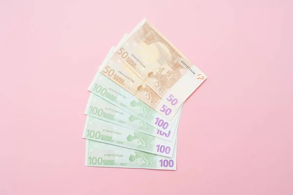 Euro argent en forme de ventilateur. Gros plan du billet sur fond rose pastel — Photo