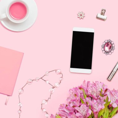 Ev ofis çalışma alanıyla boşaltmak. Düz lay, dergiler, sosyal medya. Üstten görünüm güzellik blog kavramı. Kadın moda aksesuarları, pembe bir arka plan üzerinde telefon.