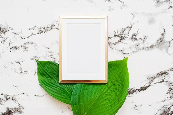 Marco fotográfico dorado con hojas tropicales sobre fondo de mármol. Simular marco con copyspace. Piso tendido, vista superior . — Foto de Stock