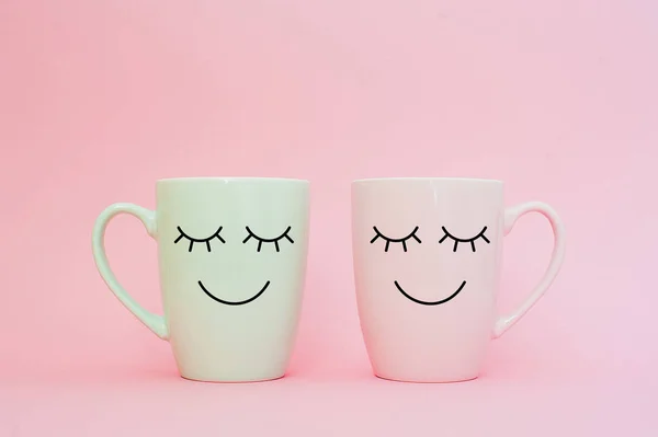 Happy friday word. Two cups of coffee stand together to be heart shape on pink background with smile face on cup. Concept about love and relationship. Creative colorful greeting card.