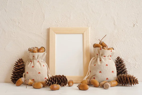 Composición otoñal con marco simulado, bellotas en bolsas de lino y conos de pino. Otoño, concepto de otoño. Copiar espacio . — Foto de Stock