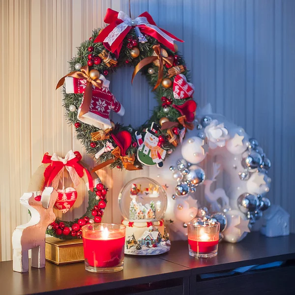Красный рождественский венок с украшениями, дома, свечи, снежный музыкальный бал — стоковое фото