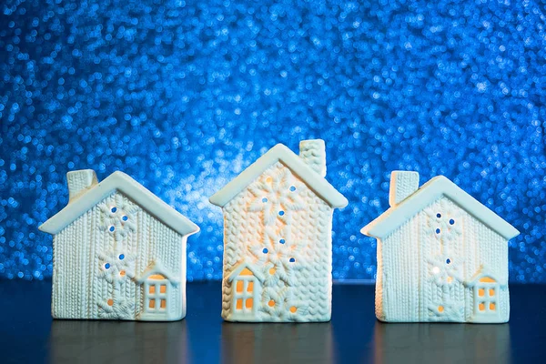 New Year background with white cottages in the snow. Lodges on Blue Blurred Glitter lights background.  hristmas house concept.
