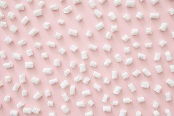 Marshmallow pattern on pastel pink background. Flat lay, top view, copy space. Winter concept.