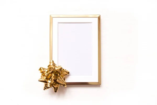 Marco dorado con lazo dorado aislado sobre fondo blanco. Invierno minimalista navidad plana laico . — Foto de Stock