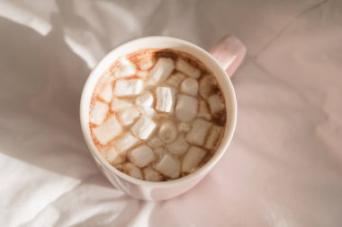 Pembe fincan sıcak çikolata şekerleme yatağın üstüne kapatın. Günaydın, Dünya