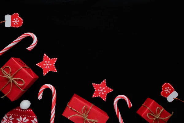 Karácsonyi összetétele. Ajándékok, édességet vesszők, piros díszek a fekete háttér. Karácsonyi, téli, újév koncepció. Lapos feküdt, felső kilátás, másol hely — Stock Fotó
