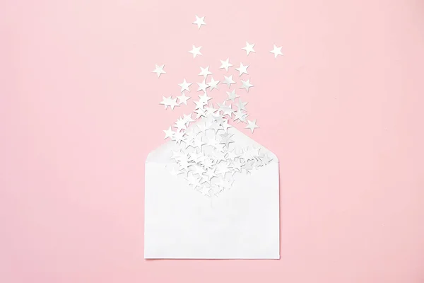 Composition de Noël. Argent étoile saupoudrer confettis dans une enveloppe sur fond rose. Carte de Noël minimale. Des vacances. Concept de félicitations . — Photo