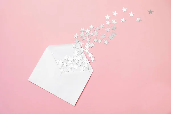 Composition de Noël. Argent étoile saupoudrer confettis dans une enveloppe sur fond rose. Carte de Noël minimale. Des vacances. Concept de félicitations . — Photo