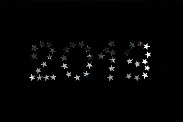 2019 新年祭典。シルバー スターは、黒い背景に紙吹雪を振りかける — ストック写真