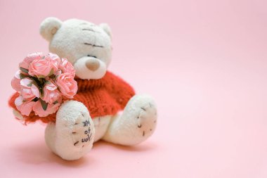 Sevgiliye arka plan. Sevimli bir oyuncak ayı oyuncak buket çiçek üzerinde pembe bir arka plan ile. 14 Şubat tebrik kartı.