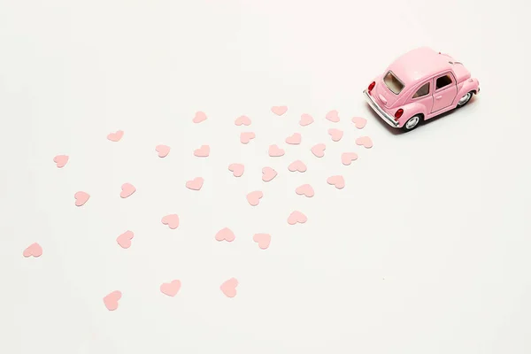 Rosa coche de juguete retro entrega ramo de flores caja sobre fondo rosa. Tarjeta del 14 de febrero para el día de San Valentín. Entrega de flores. 8 de marzo, Día Internacional de la Mujer . —  Fotos de Stock