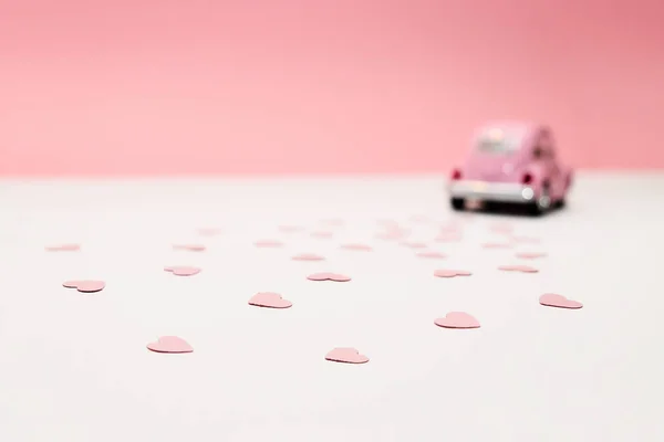 Carro de brinquedo retro rosa entregando corações no fundo rosa. 14 de fevereiro cartão para o dia dos namorados. Entrega de flores. 8 de março, Dia Internacional da Mulher Feliz . — Fotografia de Stock